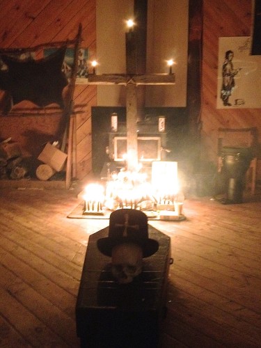 The cairn of stones and a wooden cross, symbols of the Underground Railroad, lit with candles to invoke the spirit of Harriet Tubman to aid our magic [Photo Credit: Todd Fashion]