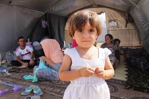 Yezidi refugee girl with her family at Newroz camp [Photo Credit: Rachel Unkovic/International Rescue Committee/UK Dept of International Development]