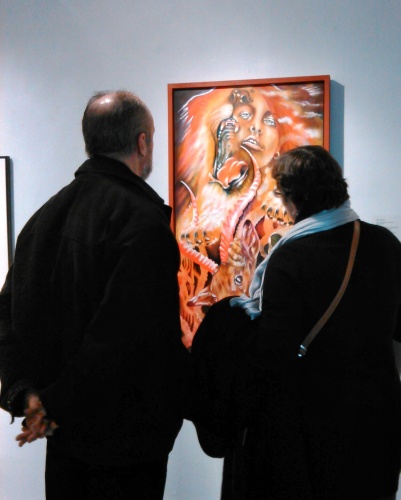 Two attendees gaze on a piece by Roger Williamson [c schulz]