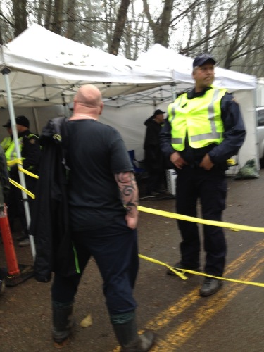 Mojo stands against the tape which marks the injection zone. The RCMP sent their biggest officer to keep him company