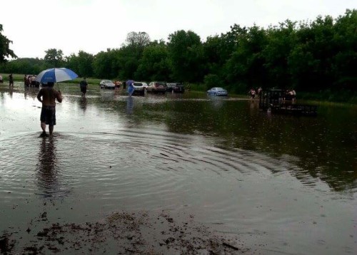 Attendees push cars out of the mud in the parking area now known as "Lake Keys." Photo by Heike Feller