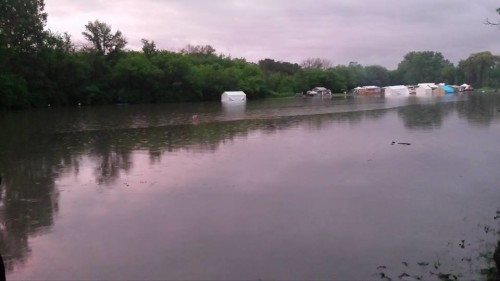 Tents in standing water in the background. Area called the Green where rituals were held. Photo by Sarah Kaczmarek