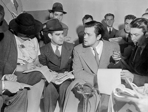 Orson Welles explains to reporters that he didn't intend to cause public panic. [Photo Credit: Acme News Photos]