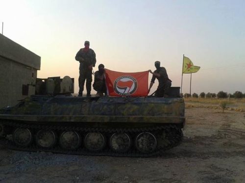 YPG fighters holding an Anti-Fascist Action flag. Photo Credit: It's Going Down.