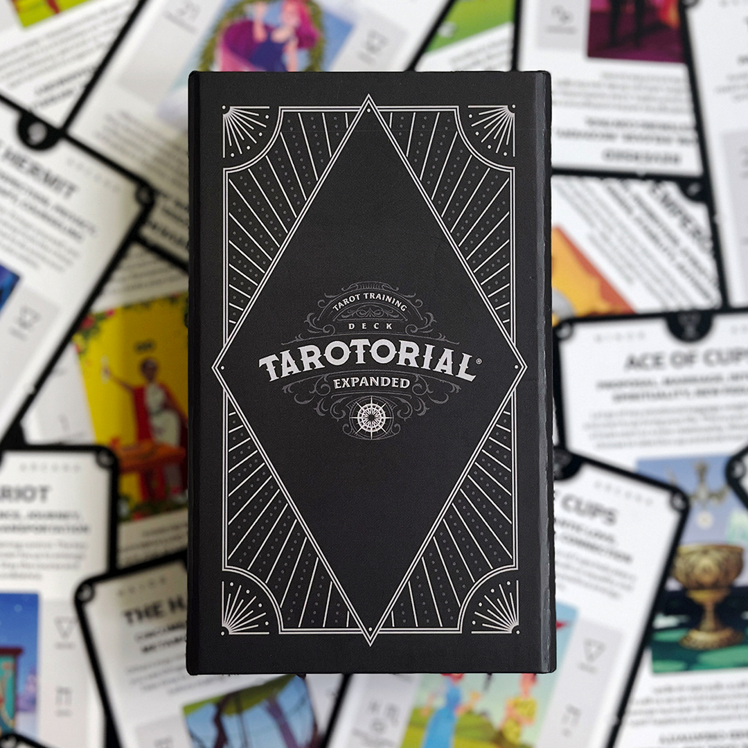 Tarotorial deck box sitting on top of some of the cards spread out face up